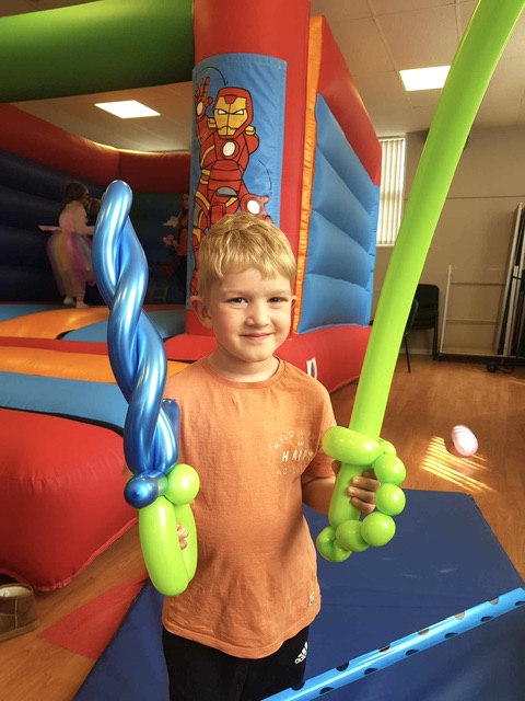 boy holding a balloon sword at a party in Telford